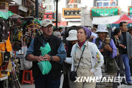 Photo taken on Oct.6, 2008 shows two foreign visitors on the Barkor street of Lhasa, capital city of northwest China's Tibet Autonomous Region. [Xinhua photo]