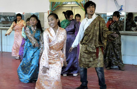 Tibetan student perform folk dance during the break in the dormitory of No. 4 High school in Yingkou, northeast China's Liaoning Province, March 10, 2009. [Xinhua photo]
