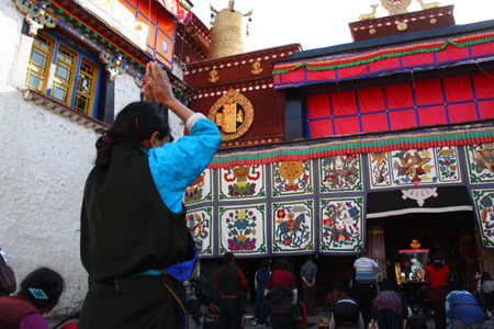 A Tibetan woman kowtows and prays in front of the Jokhang Temple in central Lhasa, capital of southwest China's Tibet Autonomous Region, March 10, 2009. [Xinhua photo]