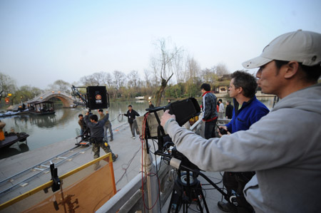 The cast and crew of new version TV series scenarized from China's classic romance 'A Dream of Red Mansions' go along with their trial shooting of breakdown scripts, at the scenery zone of Xi Chun Tai, or the Brightening Springtide Platform on the Slim West Lake, in Yangzhou City, east China's Jiangsu Province, March 9, 2009.