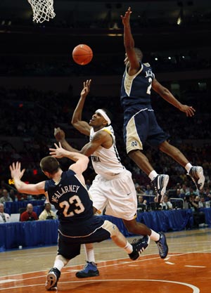 University of West Virginia's Devin Ebanks (C) shoots as he is fouled over Notre Dame University's Kyle McAlarney (L) and Tory Jackson during the first half of their game at the 2009 NCAA Big East men's college basketball tournament in New York, March 11, 2009.