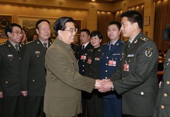 Chinese President Hu Jintao (front L), who is also chairman of the Central Military Commission, shakes hands with a deputy of the Chinese People's Liberation Army (PLA) to the Second Session of the 11th National People's Congress (NPC), in Beijing, capital of China, March 11, 2009. Hu Jintao attended the plenary meeting of the PLA delegation on Wednesday. [Wang Jianmin/Xinhua] 