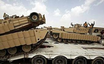US soldiers load their tanks on tank-carriers at Al-Rustumiyah military base, southeast of Baghdad. A suicide bomber on Tuesday killed 33 people, including tribal chiefs, soldiers and two journalists, in the second major attack around Baghdad in two days, officials said.[Ahmad al-Rubaye/CCTV/AFP] 