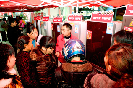 Rural residents in hustle and bustle pick out arrays of refrigerators on sales with governmental subsidies at the trade fair tour for sales promotion of home appliances to countryside, at Yanghe Township, Huaying City, southwest China's Sichuan Province, March 11, 2009. 