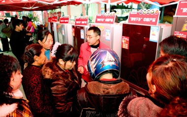 Rural residents in hustle and bustle pick out arrays of refrigerators on sales with governmental subsidies at the trade fair tour for sales promotion of home appliances to countryside, at Yanghe Township, Huaying City, southwest China's Sichuan Province, March 11, 2009.