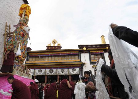 Lamas and believers pray in front of the ghee figures of Buddha, in the Chanbaling Temple in Qamdo, southwest China's Tibet Autonomous Region, Mar. 11, 2009. An annual celebration for the ghee flowers and lanterns festival was held in the Chanbaling Temple on Wednesday, to pray for peace and happiness in the new year. 