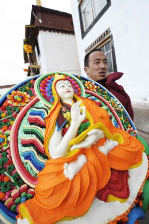 A Lama carries a ghee figure of Buddha in the Chanbaling Temple in Qamdo, southwest China's Tibet Autonomous Region, Mar. 11, 2009. An annual celebration for the ghee flowers and lanterns festival was held in the Chanbaling Temple on Wednesday, to pray for peace and happiness in the new year. 