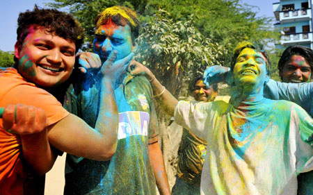 Indians get gulal (coloured power) smeared onto their faces during celebrations of Holi in New Delhi on March 11, 2009. Holi, also known as festival of colours, heralds the beginning of spring and is celebrated with great enthusiasm all over India. 