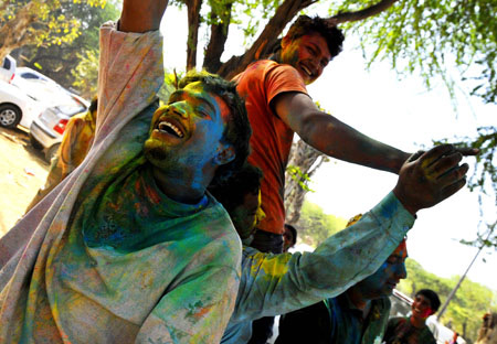 Indians get gulal (coloured power) smeared onto their faces during celebrations of Holi in New Delhi on March 11, 2009. Holi, also known as festival of colours, heralds the beginning of spring and is celebrated with great enthusiasm all over India.