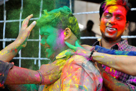 Indians get gulal (coloured power) smeared onto their faces during celebrations of Holi in New Delhi on March 11, 2009. Holi, also known as festival of colours, heralds the beginning of spring and is celebrated with great enthusiasm all over India. 