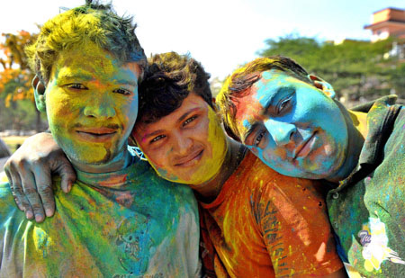 Indian kids smile with their faces smeared with coloured powders during celebrations of Holi in New Delhi on March 11, 2009. Holi, also known as festival of colours, heralds the beginning of spring and is celebrated with great enthusiasm all over India. 