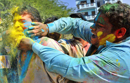 Indians get gulal (coloured power) smeared onto their faces during celebrations of Holi in New Delhi on March 11, 2009. Holi, also known as festival of colours, heralds the beginning of spring and is celebrated with great enthusiasm all over India. 