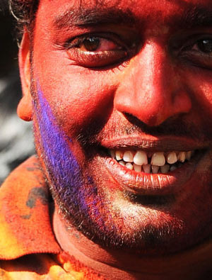 An Indian reacts with his face smeared with coloured powders during celebrations of Holi in New Delhi on March 11, 2009. Holi, also known as festival of colours, heralds the beginning of spring and is celebrated with great enthusiasm all over India. 