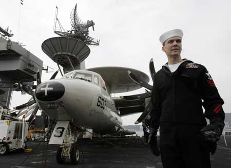 A soldier of U.S. aircraft carrier USS John C. Stennis stands besides E-2C Hawkeye on a flight deck after the aircraft arrived at a South Korean naval base in Busan, about 420 km (262 miles) southeast of Seoul, March 11, 2009.