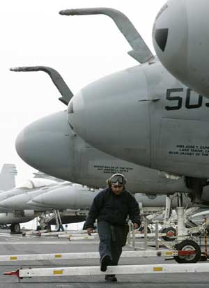 A maintenance staff walks besides EA-6B Prowler aircrafts on a flight deck after U.S. aircraft carrier USS John C. Stennis arrived at a South Korean naval base in Busan, about 420 km (262 miles) southeast of Seoul, March 11, 2009. 