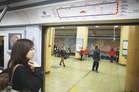 A female passenger waits for the resume of subway system in the carriage at the Chaoyangmen station of metro Line 2 subway in downtown Beijing, China, March 12, 2009. 