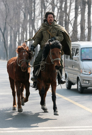 Chinese-Russian Li Jing rides on his horse on a road at Changping District of Beijing, capital of China, Mar. 10, 2009. (Xinhua/Zhou Guoqiang)