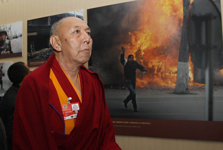 A member of the 11th National Committee of the Chinese People's Political Consultative Conference (CPPCC) from southwest China's Tibet Autonomous Region, who is attending the Second Session of the 11th National Committee of the CPPCC, visits an exhibition titled 'Democratic Reform in the Tibet Autonomous Region' at the Cultural Palace of Nationalities in Beijing, capital of China, March 11, 2009.