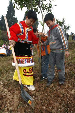 Students of Suining plant a sapling presenting friendship with a student of Tibet ethnic group in Suining City, southwest China's Sichuan Province, Mar. 11, 2009. [Xinhua photo]