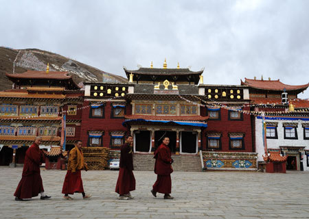 Monks walk by the building of Lhakang Temple, 110 kilometers to Kangding City in southwest China's Sichuan Province, March 4, 2009. 