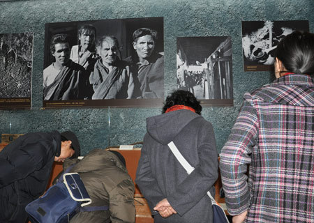 Visitors look at objects that were used by serf owners to torture serfs in old Tibet at an exhibition marking the 50th anniversary of the Democratic Reform in Tibet Autonomous Region in Beijing, Feb. 25, 2009. (Xinhuanet Photo)