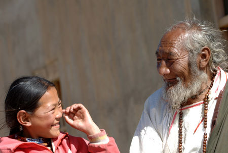 An old man and his granddaughter share a happy moment in Nagqu Town, southwest China's Tibet Autonomous Region, June 13, 2006. [Xinhua photo]