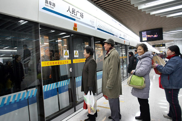 2 Passengers queue on the platform for the train heading to People’s Square, a transfer station of Metro Line 8, currently in operation to relieve traffic congestion in Shanghai.