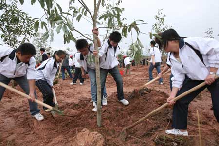 Students of Wuyishan Institute plant a sapling in Wuyishan, southeast China's Fujian Province, Mar. 12, 2009. 