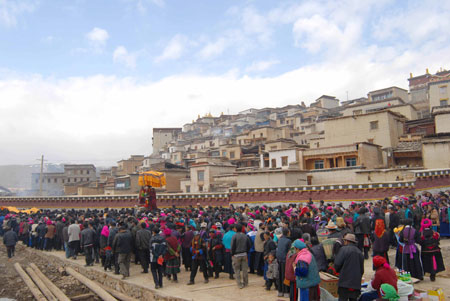  grand Buddha-greeting parade passes by the Gedan Songzanlin Lamasery, a renowned and historic Tibetan Buddhist temple in Shangri-la County, southwest China's Yunnan Province, March 11, 2009. 