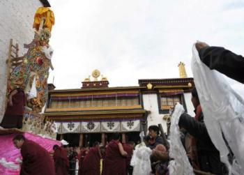 Lamas and believers pray in front of the ghee figures of Buddha, in the Chanbaling Temple in Qamdo, southwest China's Tibet Autonomous Region, Mar. 11, 2009. An annual celebration for the ghee flowers and lanterns festival was held in the Chanbaling Temple on Wednesday, to pray for peace and happiness in the new year. [Pubu Zhaxi/Xinhua] 