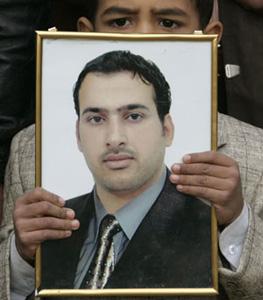 Adel, nephew of TV reporter Muntazer al-Zaidi, displays a picture of his uncle during a protest by Zaidi's relatives demanding his release from jail in central Baghdad December 19, 2008.[Xinhua/Reuters Photo] 