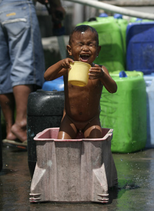 A Filipine boy takes a bath from free water stations in the poor residents of Tondo in Manila, the Philippines, March 12, 2009. A temperature of 33.3 degrees Celsius was recorded at 1:50 p.m Wednesday. Relative humidity was registered at 96 percent. So far, the hottest day in Metro Manila was on March 6 at 36 degrees Celsius. 