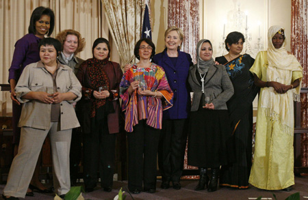 U.S. first lady Michelle Obama (L) and Secretary of State Hillary Clinton (4th R) pose with recipients of this year's Secretary of State's Award for International Women of Courage in Washington March 11, 2009. 