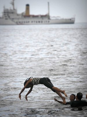 Filipinos cool off from the heat of summer by diving in the murky waters of the Manila Bay despite government's ban against swimming in the area in Manila, the Philippines, March 12, 2009.