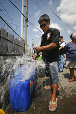 A local official helps bring water to the poor residents of Tondo in Manila, the Philippines, March 12, 2009. 