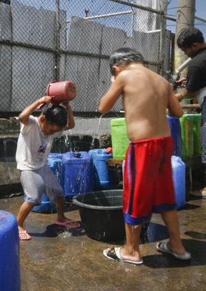 Filipino children take a bath from free water stations in the poor residents of Tondo in Manila, the Philippines, March 12, 2009. 