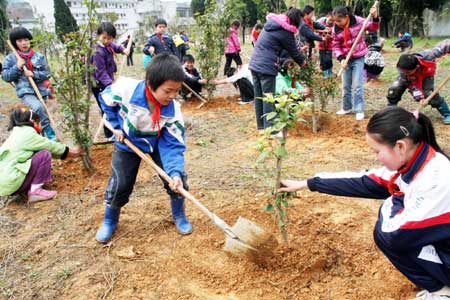 Students of Sizhou primary school plant saplings in Dexing City, east China's Jiangxi Province, Mar. 12, 2009. Tree-planting campaigns were carried out all around the country Thursday to welcome the country's 31st Tree-planting Day. 
