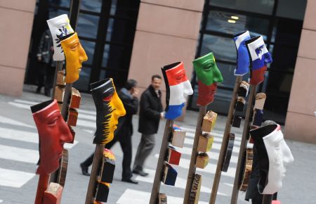 People pass by a group of creations featuring 27 masks with national colours of 27 EU member states in the European Parliament in Strasbourg, France, March 12, 2009. The creation was based on the mask of Roman Cavarly helmet unearthed in the ruins of the Teutonburg Forest Battle, which was a crucial fight between Germanic Tribes and Roman Empire occurred on 9 AD. The masks were created as a symbol of peace and of cooperation in the European region nowadays. (Xinhua/Wu Wei)