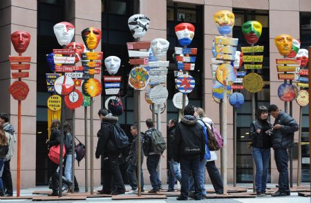 Some students view a group of creations featuring 27 masks with national colours of 27 EU member states in the European Parliament in Strasbourg, France, March 12, 2009.