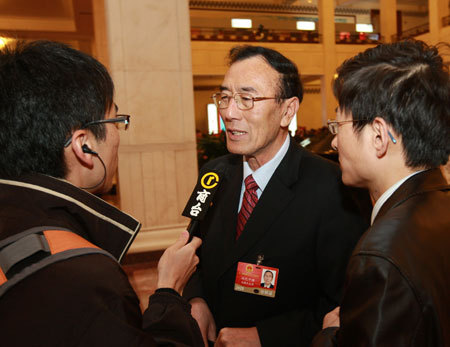 Qiangba Puncog (C), deputy to the Second Session of the 11th National People's Congress (NPC) from southwest China's Tibet Autonomous Region, receives interview prior to the third plenary meeting of the Second Session of the 11th NPC held at the Great Hall of the People in Beijing, March 10, 2009. [Xinhua Photo]
