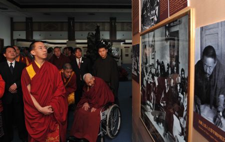 The 11th Panchen Lama Erdeni Gyaincain Norbu (front) looks at the exhibits during an exhibition titled 'Democratic Reform in the Tibet Autonomous Region' in Beijing, capital of China, March 15, 2009. [Xinhua]