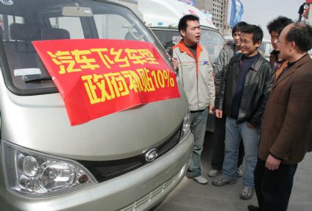 Local peasants prone to purchase of a minivan read the notice of 10 percent subsidies on designated types of automobile promoted to countryside, in Linyi City, east China's Shandong Province, March 15, 2009. 