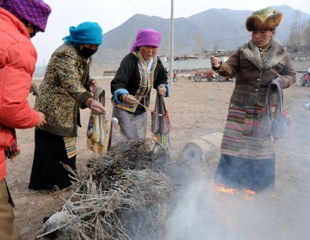 Local villagers burn joss sticks during a ceremony to mark the start of the spring farming season at Shexing Village, Doilung Deqen County, southwest China's Tibet Autonomous Region, March 15, 2009. [Soinam Norbu/Xinhua]