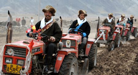 Local villagers drive tractors in a row during a ceremony to mark the start of the spring farming season at Shexing Village, Doilung Deqen County, southwest China's Tibet Autonomous Region, March 15, 2009. [Soinam Norbu/Xinhua]