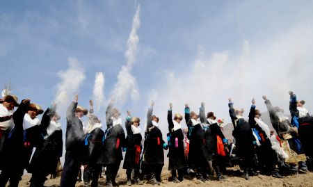 Tractor drivers throw Tsampa up into the air during a ceremony to mark the start of the spring farming season at Dagze County, southwest China's Tibet Autonomous Region, March 15, 2009. [Chogo/Xinhua]