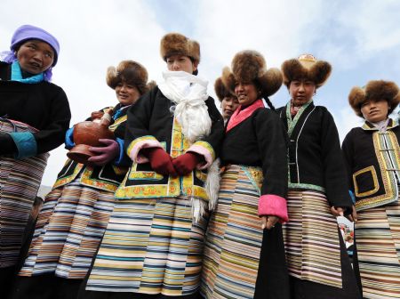 Women present highland barley wine to tractor drivers during a ceremony to mark the start of the spring farming season at Dagze County, southwest China's Tibet Autonomous Region, March 15, 2009. [Chogo/Xinhua]