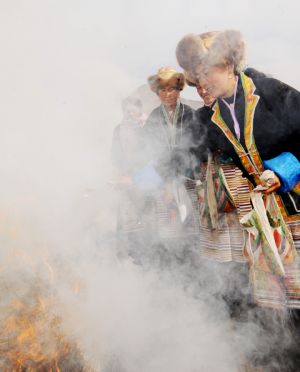  Women burn mulberry leaves during a ceremony to mark the start of the spring farming season at Dagze County, southwest China's Tibet Autonomous Region, March 15, 2009. [Chogo/Xinhua]