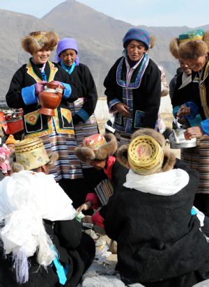 Women present highland barley wine to tractor drivers during a ceremony to mark the start of the spring farming season at Dagze County, southwest China's Tibet Autonomous Region, March 15, 2009. [Chogo/Xinhua]