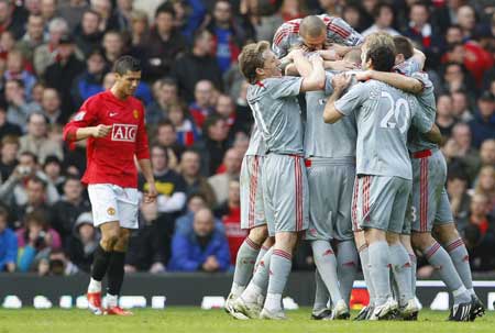 Liverpool's players celebrate after Fabio Aurelio (hidden) scores as Manchester United's Cristiano Ronaldo (L) looks on during their English Premier League soccer match in Manchester, northern England, March 14, 2009. [Xinhua/Reuters]