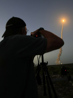 A news photographer photographs launch of the space shuttle Discovery at the Kennedy Space Center in Cape Canaveral, Florida March 15, 2009. [Xinhua/Reuters]